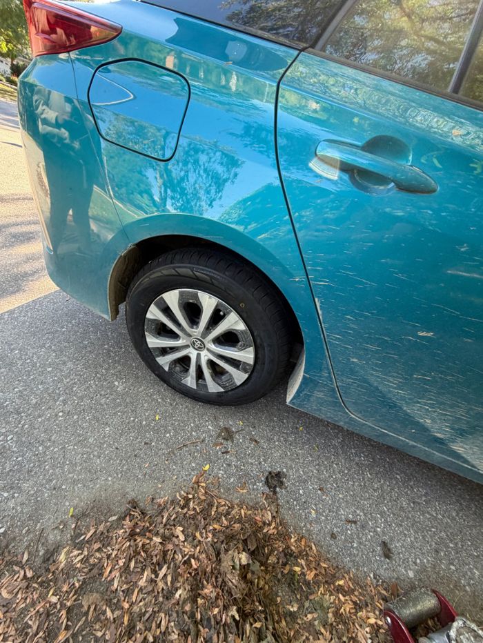 Rear wheel fitted to a blue vehicle with tools nearby