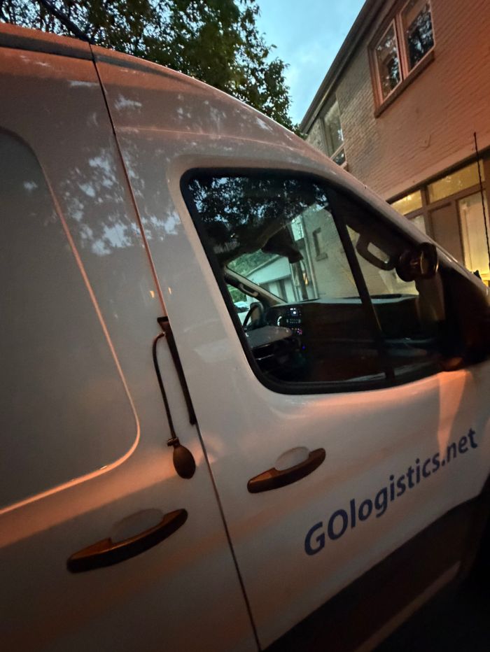 White van with access tools at the driver window at dusk